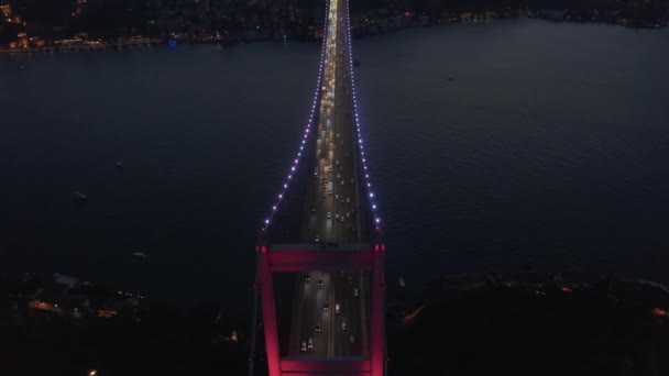Gyönyörű piros híd felett Bosphorus a piros fény éjjel a gépkocsi forgalom, légi madarak szem nézet billenjen le — Stock videók