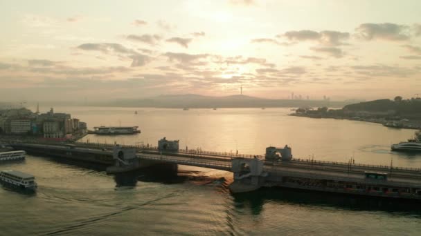 Galata-Brücke über den Bosporus im goldenen Sonnenaufgangslicht mit Booten auf dem Wasser, Antenne links — Stockvideo