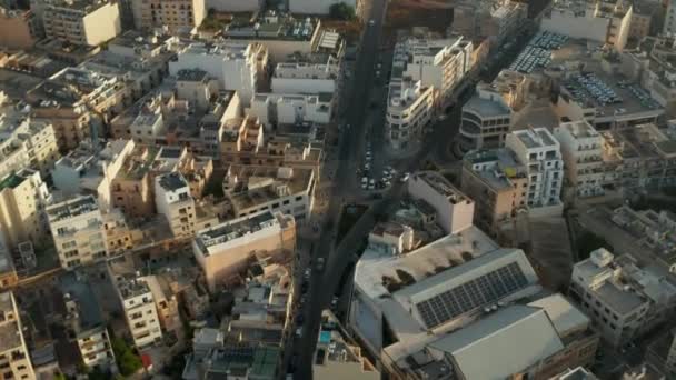 Дорога, проходящая через остров Мальта с бежевыми коричневыми зданиями в солнечном свете, воздушный беспилотный кран вверх — стоковое видео