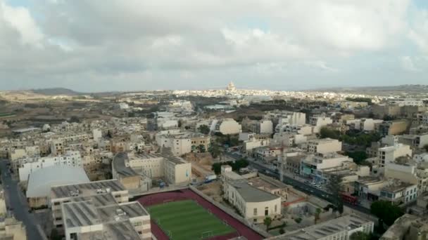 Быстрый переход Hyperlapse над островом Гозо, Мальта с церковью вдали и пасмурное небо, Воздушный вперед куклы — стоковое видео