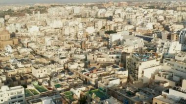 Malta Adası 'ndaki Güneş Işığı' nda Bej Kahverengi Apartman Blokları, Hava Aracı Dolly 'i öne doğru eğdi.