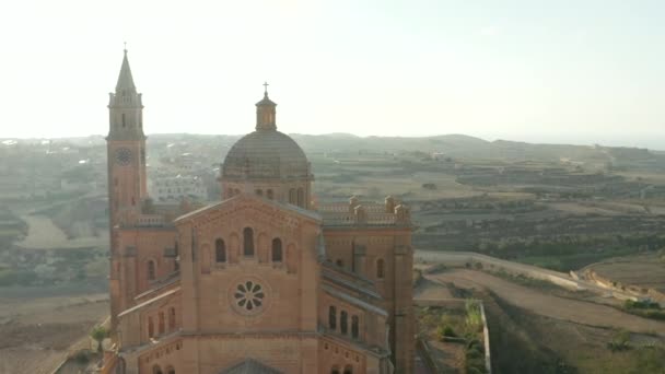 马耳他戈佐郊区美丽的褐色沙滩教堂，下午阳光明媚，空中滑行右 — 图库视频影像