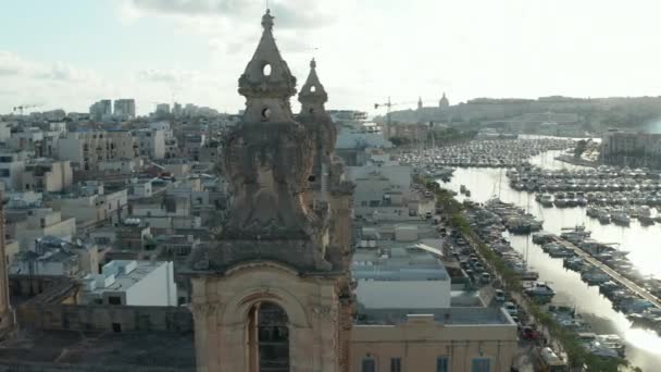 Close up of Two Church Bell towers on Malta with Sailboats and Yacht Port in background on beautiful Sunny Day, Aerial slide left — Stock Video