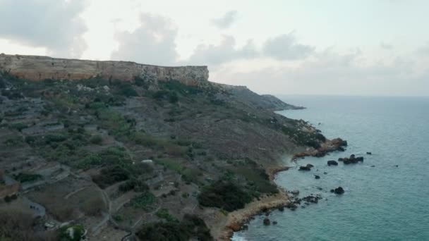 崖と海の波と夕日のマルタ島の海岸線、空中ドローンの視点はドリー — ストック動画