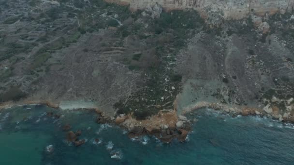 岩の上に青い海の波がクラッシュし、地中海の島の美しい海岸線、空中鳥の目が下のビューを傾ける — ストック動画