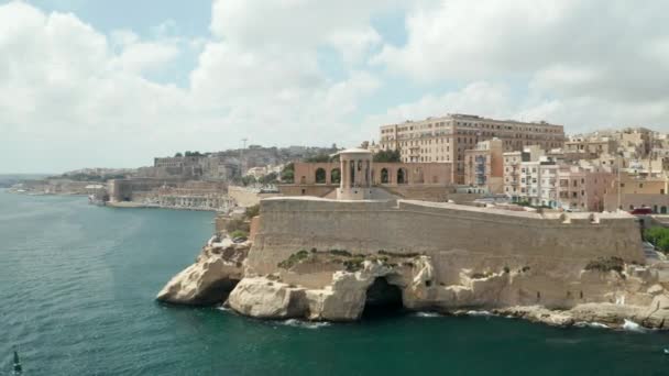 Malta 'nın başkenti Valletta' da bulunan ünlü Kuşatma Çanı Savaşı Anıtı, geriye doğru giden Hava Dronu geçen bir kargo gemisini gözler önüne seriyor. — Stok video