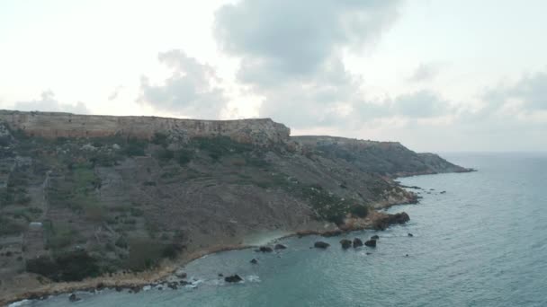 Bred utsikt över kusten i Gozo, Malta Island vid solnedgången med Cliff och Ocean Waves, antenn omvänd dolly bakåt — Stockvideo