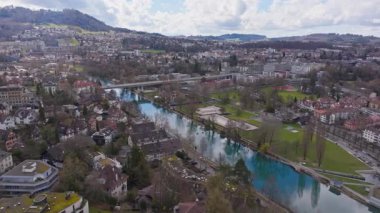 Berns 'in ortaçağ merkezini gösteren üç ayaklı panoramik manzarası, Aare Nehri' ni çevreleyen tarihi ufuk çizgisi mimari kentsel arazi boyunca yılan yolu..