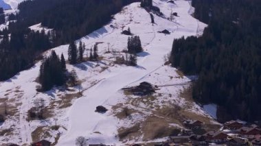 İsviçre 'nin Gstaad kentinde, İsviçre Alplerinde turistler için popüler bir kış sporları merkezi olan karlı yamaçların ve kayak asansörlerinin hava manzarası.