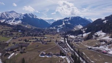 Alp tepeleri arasında yuva yapmış Gstaad 'ı kaplayan hava manzarasında geleneksel ahşap bardaklar ve kış güneşinde yıkanan el değmemiş kayak arazileri yer alıyor..