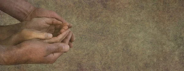 Seeking your help  charity campaign banner - male hands gently cupped around female cupped hands on a rustic stone effect background with space for a message