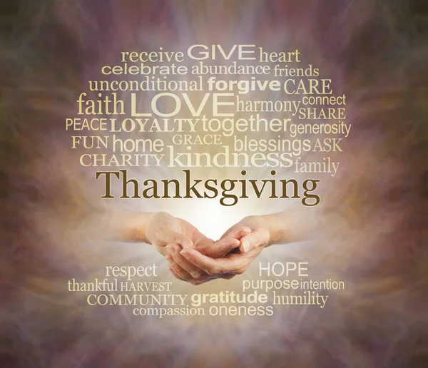 Words associated with the Thanksgiving Holiday - female hands gently cupped surrounded by a THANKSGIVING word cloud emerging from warm coloured background