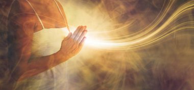 Peaceful prayer sending love and light out -  female in white dress with hands in prayer position and a stream or white light flowing outwards with a rustic golden brown ethereal energy background clipart