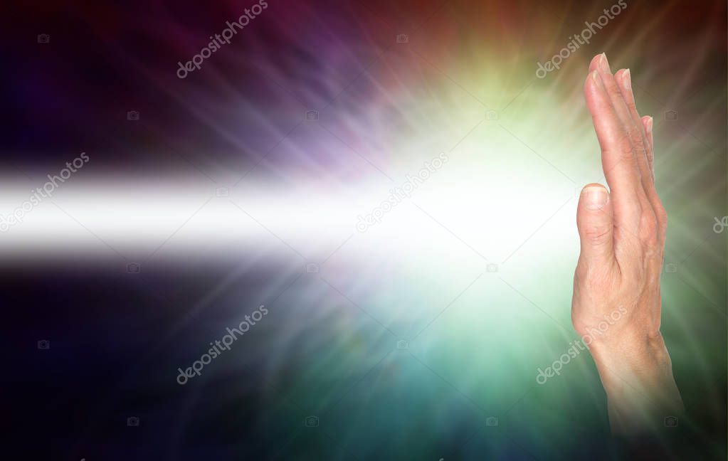 Sending distant healing energy with right hand palm chakra -  female hand facing out with a beam of white energy streaming out and copy space