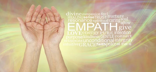 The healing hands of an empath - pair of female hands gently cupped beside an EMPATH word cloud against a lemon laser light swish energy background