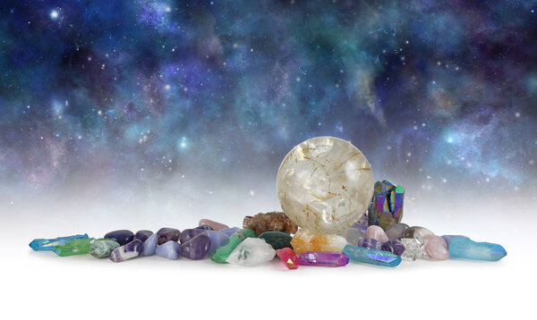 Cosmic Space Crystals Background Banner - Huge rutilated Crystal Ball surrounded by tumbled healing stones and terminated quartz with space for copy above in celestial dark night sky