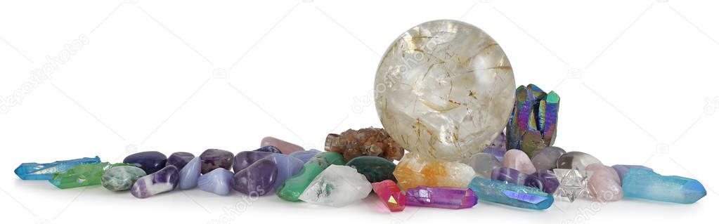 Row of multicoloured Healing Crystals Background Banner - Huge rutilated Crystal Ball surrounded by various tumbled healing stones and terminated quartz with space for copy