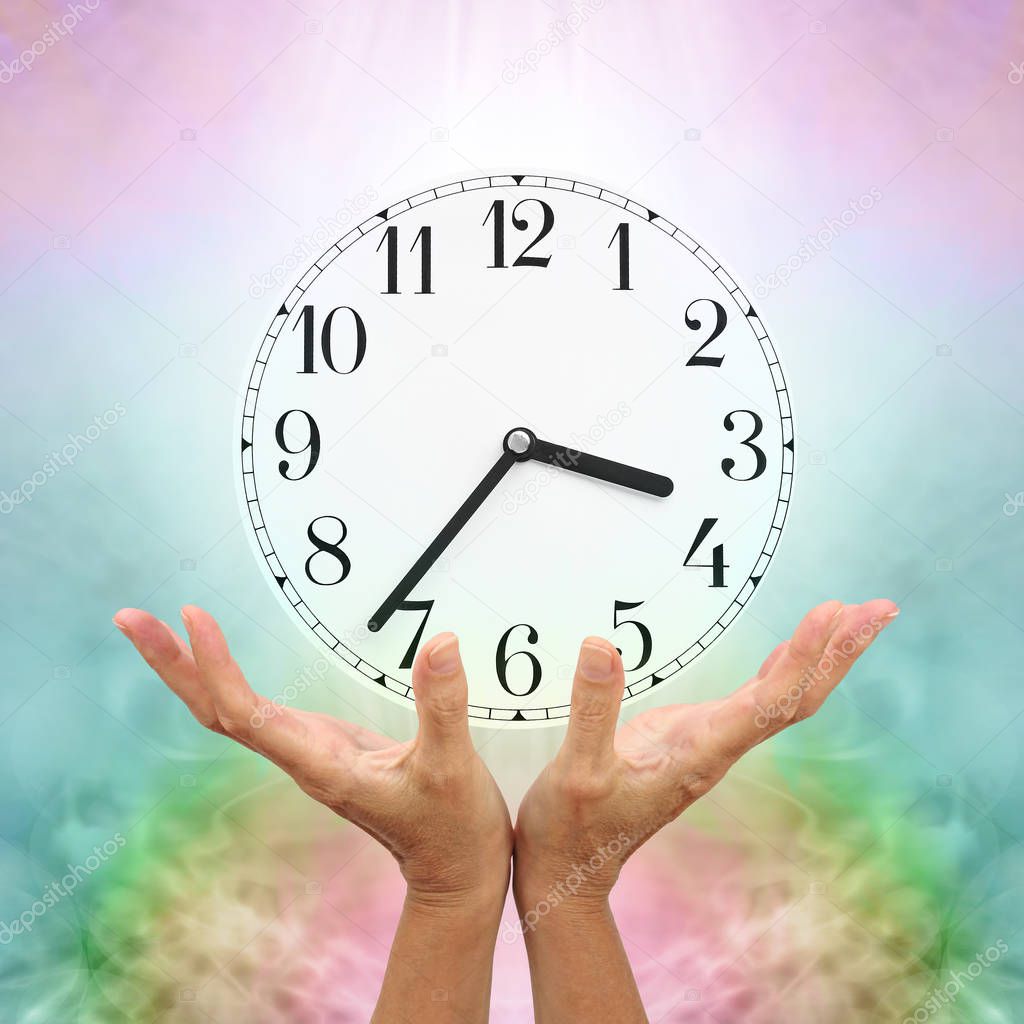Make time for healing - female cupped open hands reaching up towards a clock face showing 3.37 against a pale multicoloured background