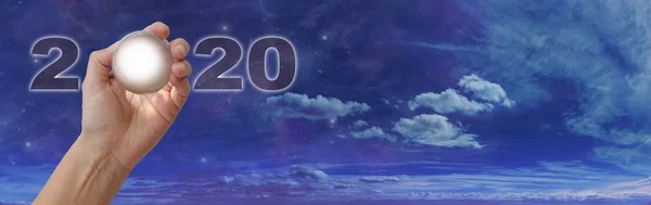 クリスタルボールリーディング あなたのために2020年を保持するものは何ですか コピースペースと広い青い曇りの夕暮れの空の背景に対して2020年の0を作る明確なクリスタルボールを保持女性の手 — ストック写真