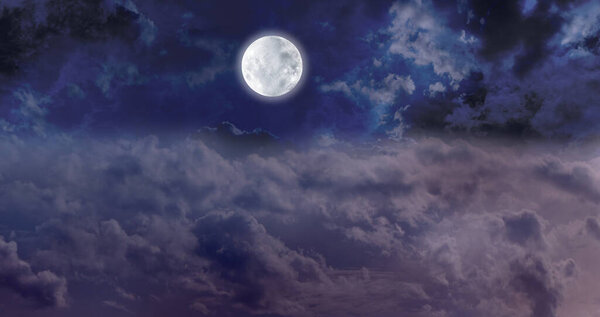High Full Moon Night Time Cloudscape - dark blue night sky with a bright full moon centrally placed above the clouds with plenty of copy space for messages