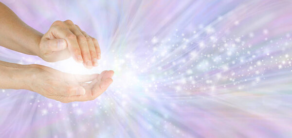 Отправка красивой высокочастотной целебной энергии - женские руки с белым светом и струящимися блестками на фоне сиреневого энергетического поля с копировальным пространством 
