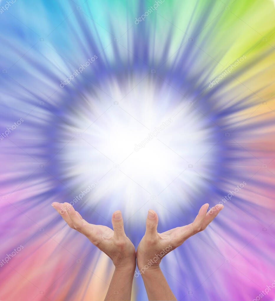 Extraordinary Multicoloured Energy Field Formation - female cupped hands reaching up to a bright white orb surrounded by rainbow colours radiating outwards with copy space 