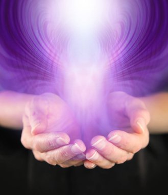 Demonstration of Paranormal Activity - cupped hands with a purple entity rising up and outwards and space for copy clipart