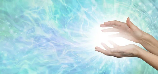 信仰ヒーラーのウェブサイトのバナーの背景 コピースペースと広い青緑色のエネルギー形成の背景との間に明るい白色の治癒エネルギーを持つ女性の手 — ストック写真