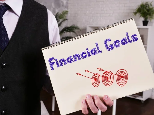 Business concept meaning Financial Goals with sign on the piece of paper.