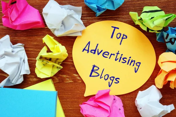 Financial concept meaning Top Advertising Blogs with inscription on the sheet.