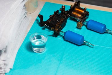 Cyan kağıdına dövme yaptırmadan önce stüdyoda enstrüman dövmesi yapıyordu.