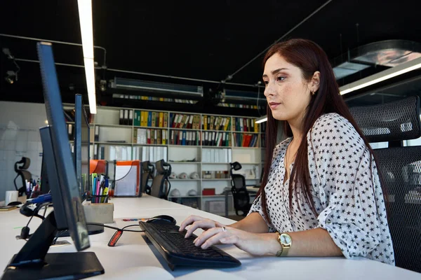 young, beautiful and empowered working woman, using a computer typing on her keyboard, business concept, technology and woman