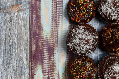 Bir bebek partisi için arka planda renkli panoların olduğu dekorasyonlu çikolatalı kekler, yukarıdan çekilmiş fotoğraf, parti konsepti, arka plan, renkler, ahşap, kekler.