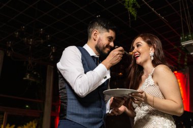 Yeni evli çift düğün pastasını tadıyor, düğün törenleri...