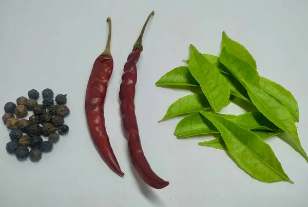 Chili Pepper, Black Pepper, Kari leaf On A White Background Stock.this photo is taken in india by vishal singh