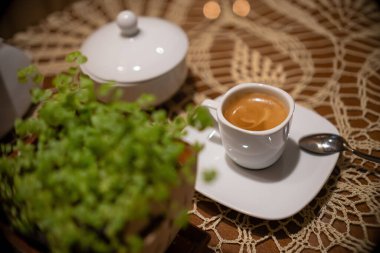 Kahve kesesi modeli, kahve fincanı ve koyu romantik arka planda süt. Mum ışığında kağıt poşet.