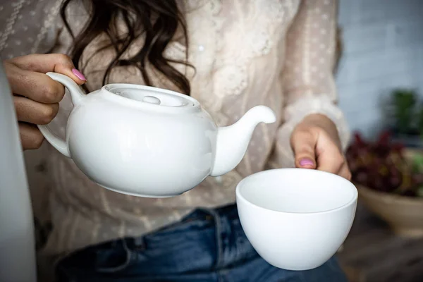Girl woman pours tea from a teapot