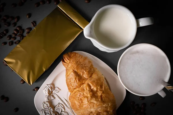 Kaffeetütchen Attrappe Mit Croissant Und Milch Bohnen Auf Dunkelblauem Hintergrund — Stockfoto