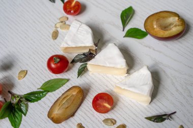 Şarküteri vejetaryen peynir, sebze ve aperatifler kurulu. Beyaz ahşap bir arka planda en üstteki tablo sahnesi.