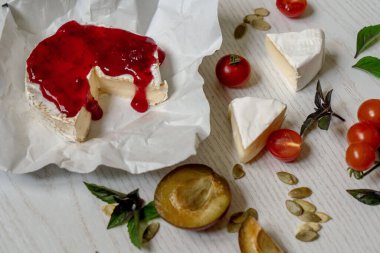 Şarküteri vejetaryen peynir, sebze ve aperatifler kurulu. Beyaz ahşap bir arka planda en üstteki tablo sahnesi.