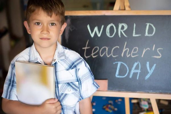 World Teacher\'s Day, pupil boy near the chalkboard, chalk text