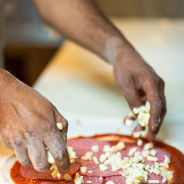 Eller pizza hazırlıyor.