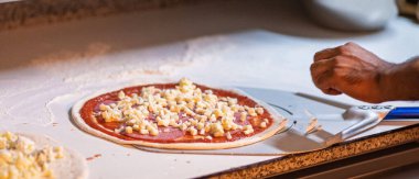 Eller pizza hazırlıyor.