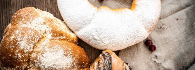 Ahşap masa zemininde taze ekmek ve çörekler var.