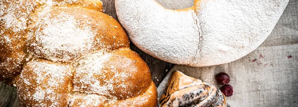 Ahşap masa zemininde taze ekmek ve çörekler var.