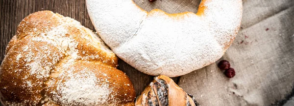 Ahşap masa zemininde taze ekmek ve çörekler var.