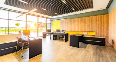 Masalı, sandalyeli, bilgisayarlı ve ofis malzemesiz modern ofis alanı.