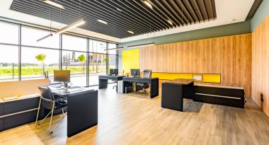 Masalı, sandalyeli, bilgisayarlı ve ofis malzemesiz modern ofis alanı.