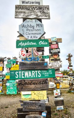 Yukon, Kanada Watson Gölü işareti yazı ormanda bir görüntü. Ziyaretçi-ebilmek eklemek onların kendi işaretleri üzerinden 80.000 zaten mevcut.