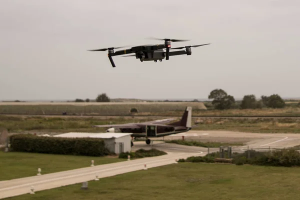 Flying Drone With Camera On The Sky over small airport